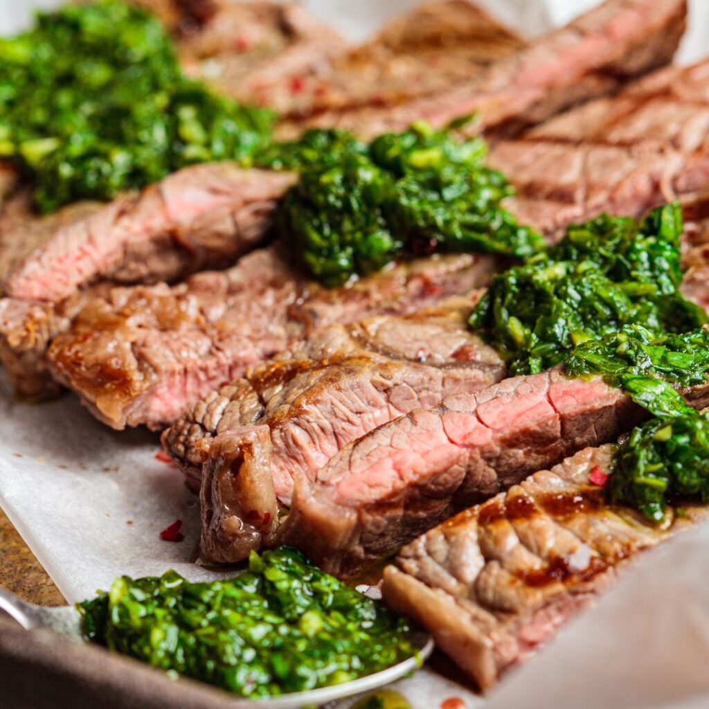 chimichurri sauce on slices of steak image by canva