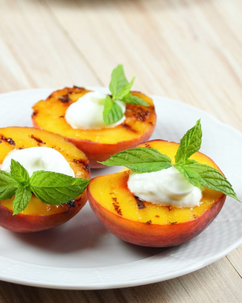 grilled peaches with mascarpone honey and mint on white plate summer dessert ideas
